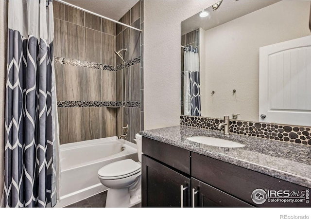 bathroom featuring vanity, tile patterned flooring, shower / bath combo with shower curtain, and toilet