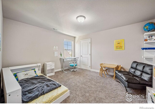 bedroom with carpet, visible vents, a textured ceiling, and baseboards