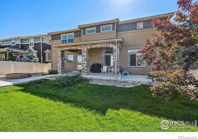 rear view of house with a patio area, fence, a lawn, and stucco siding