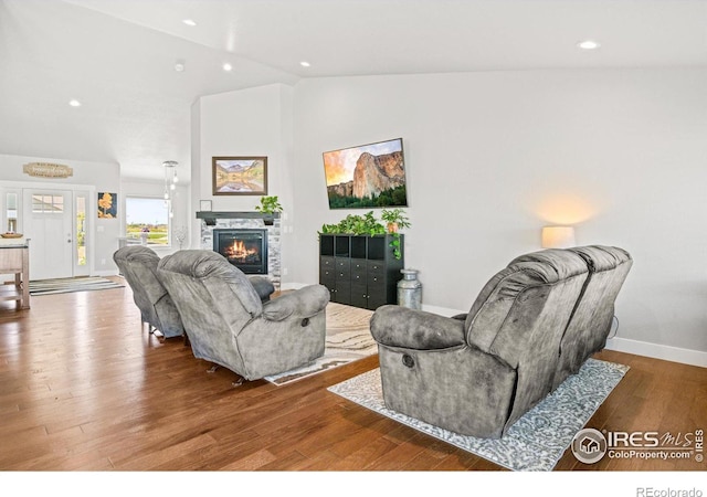 living room featuring a fireplace, hardwood / wood-style floors, and lofted ceiling