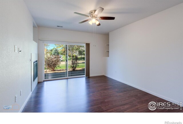 spare room with dark wood-type flooring and ceiling fan