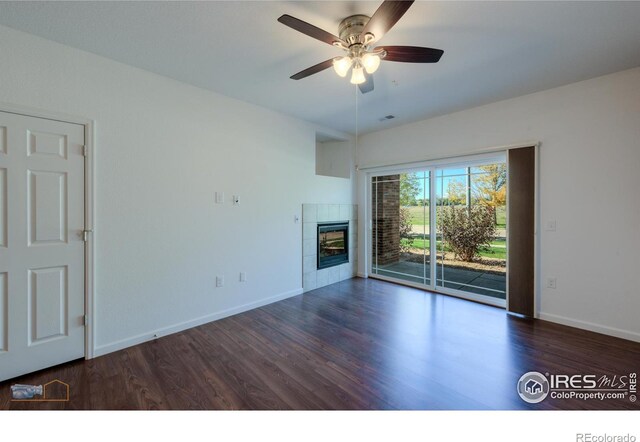 unfurnished living room with a fireplace, dark wood-type flooring, and ceiling fan