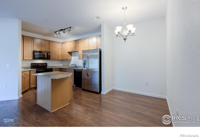 kitchen with black appliances, a center island, dark wood-type flooring, and decorative light fixtures