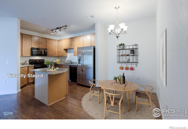 kitchen featuring pendant lighting, dark wood-type flooring, a kitchen island, an inviting chandelier, and black appliances