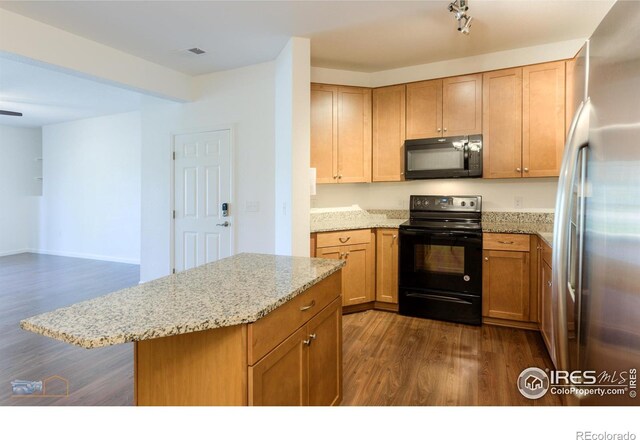 kitchen with light stone countertops, dark hardwood / wood-style flooring, and black appliances