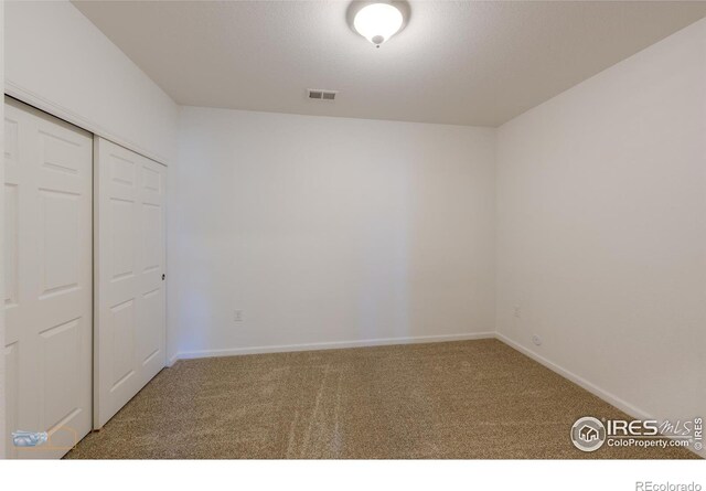 unfurnished bedroom featuring carpet floors and a closet