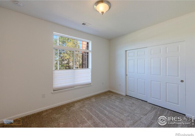 unfurnished bedroom with carpet and a closet