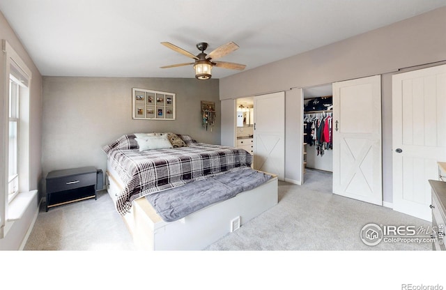 bedroom with ensuite bath, a ceiling fan, a closet, and light colored carpet