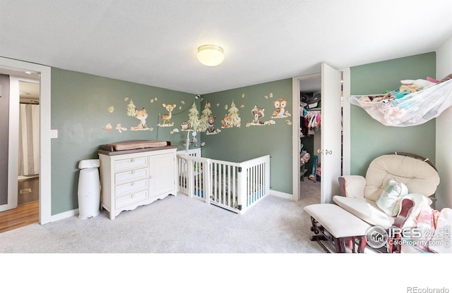 carpeted bedroom with a closet, a spacious closet, and baseboards