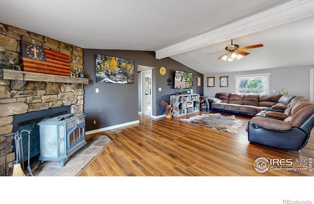 living area with vaulted ceiling with beams, visible vents, a ceiling fan, wood finished floors, and baseboards