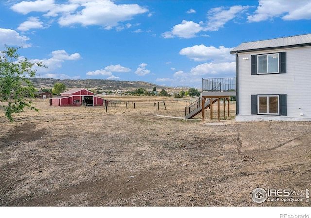 view of yard with a mountain view, an outdoor structure, and a rural view