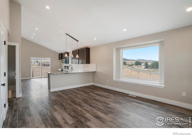 kitchen featuring a healthy amount of sunlight, kitchen peninsula, dark brown cabinets, and dark hardwood / wood-style flooring