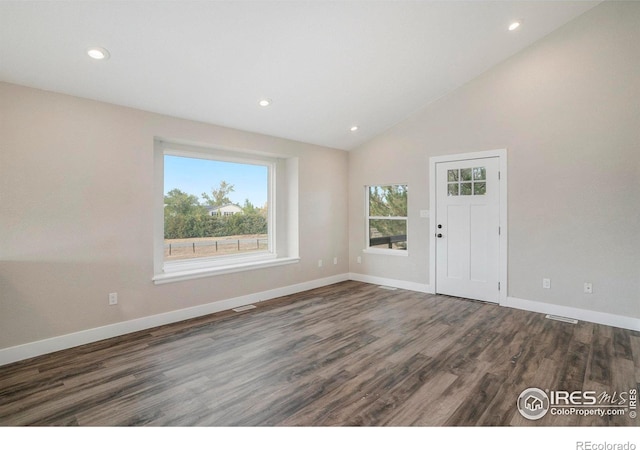 foyer with dark wood-type flooring and high vaulted ceiling