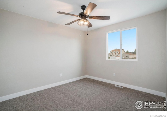 carpeted spare room with ceiling fan