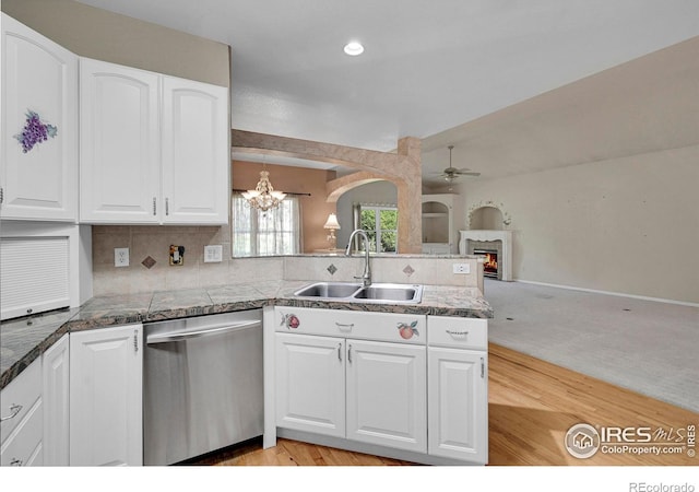 kitchen featuring ceiling fan with notable chandelier, white cabinetry, dishwasher, sink, and kitchen peninsula