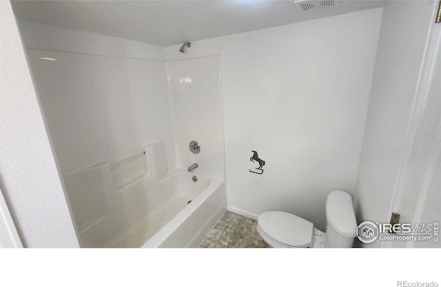 bathroom featuring bathtub / shower combination, tile patterned floors, and toilet