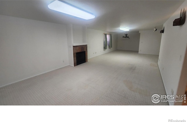 basement featuring a fireplace and light colored carpet