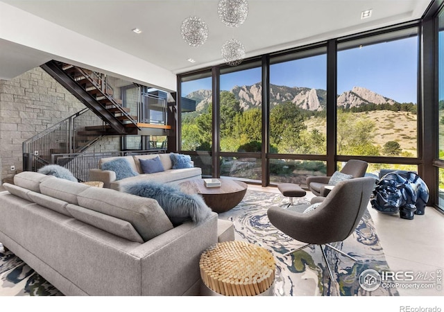 living room with floor to ceiling windows, concrete floors, a mountain view, and a healthy amount of sunlight