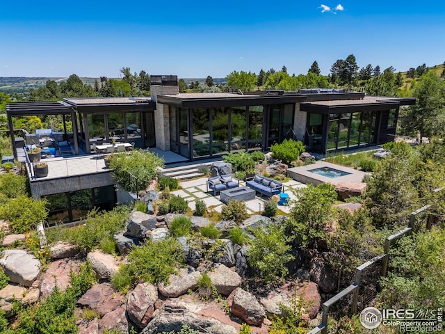 exterior space featuring an outdoor hangout area, a pool with hot tub, and a patio area