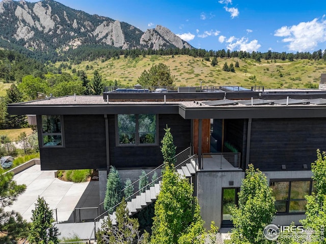 rear view of house with a mountain view and a balcony