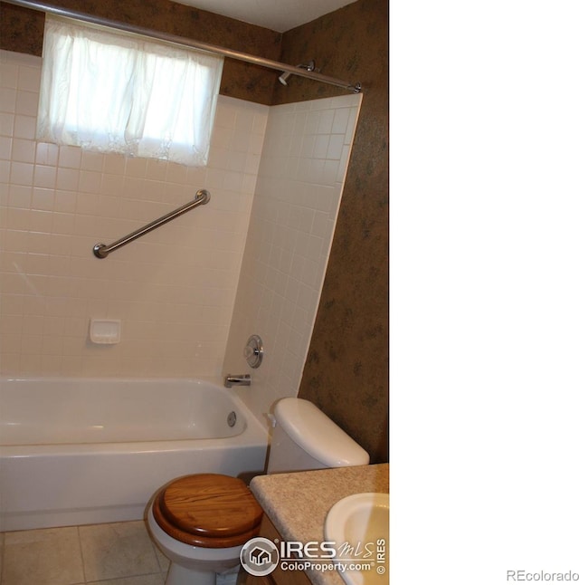 full bathroom featuring toilet, tiled shower / bath, vanity, and tile patterned floors