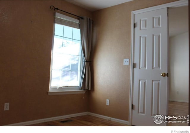 unfurnished room featuring hardwood / wood-style flooring