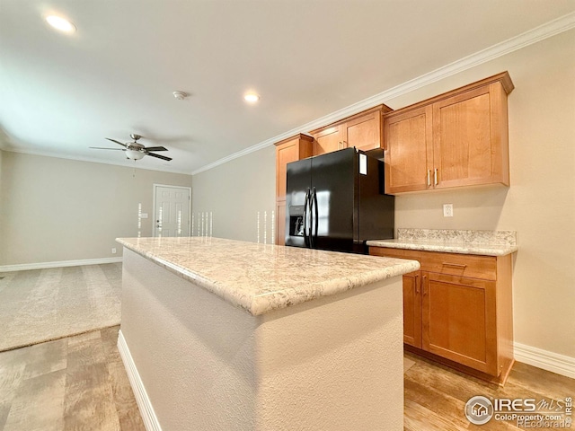 kitchen with a kitchen island, black refrigerator with ice dispenser, ornamental molding, light hardwood / wood-style floors, and ceiling fan