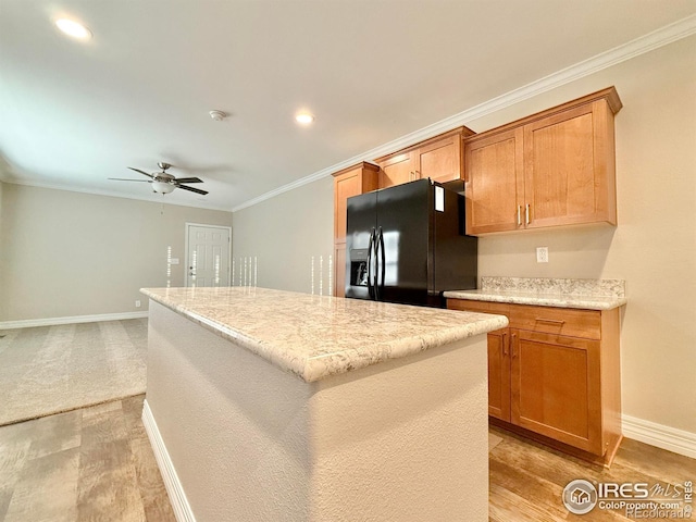kitchen with baseboards, a center island, a ceiling fan, black fridge with ice dispenser, and light wood finished floors