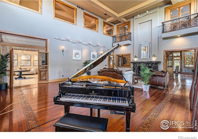 misc room with coffered ceiling, a towering ceiling, and hardwood / wood-style flooring