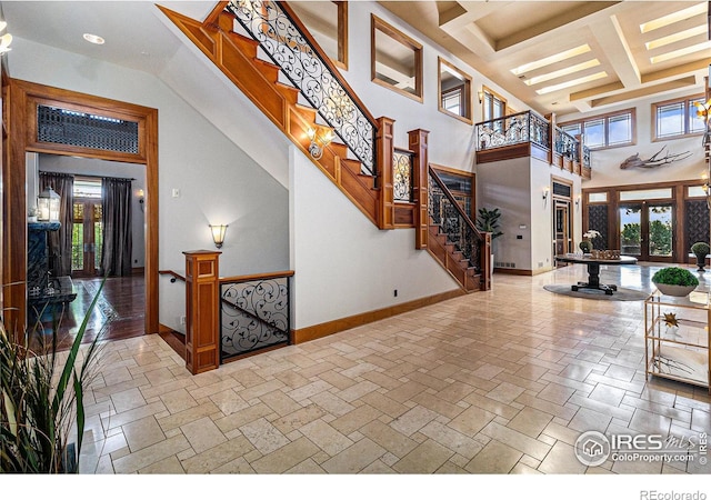 foyer with coffered ceiling and a towering ceiling