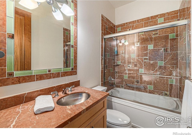 full bathroom featuring vanity, enclosed tub / shower combo, and toilet