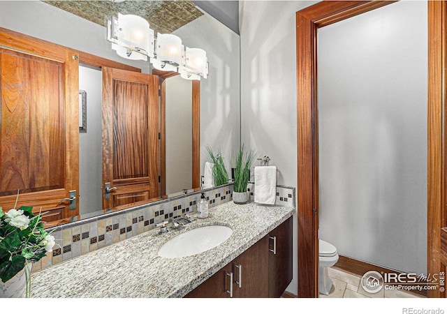 8532 Strawberry Ln, Niwot, CO 80503 - bathroom with toilet, tasteful backsplash, and vanity