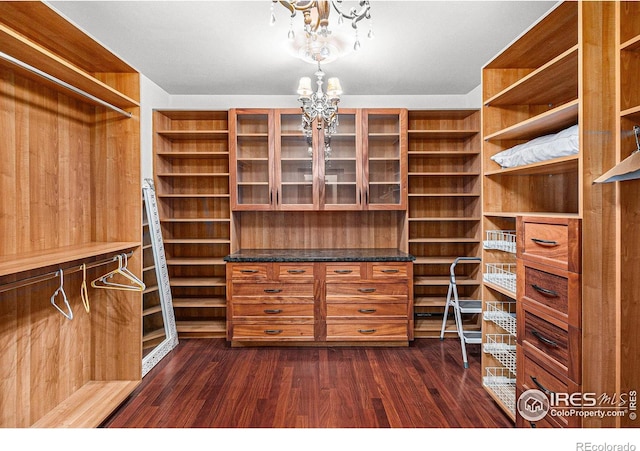 spacious closet featuring dark wood-type flooring and a chandelier