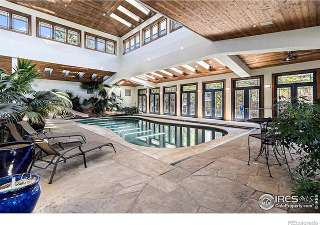 view of swimming pool with a hot tub, ceiling fan, and french doors