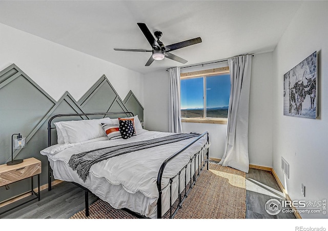 bedroom with ceiling fan and dark wood-type flooring