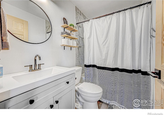 bathroom with walk in shower, vanity, and toilet