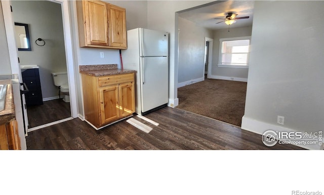 101-105 Factory St, Sterling, CO 80751 - kitchen with freestanding refrigerator, dark wood finished floors, a ceiling fan, and dark countertops