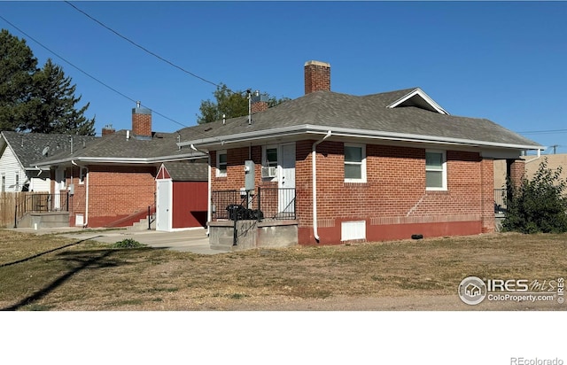 101-105 Factory St, Sterling, CO 80751 - back of house with brick siding, a lawn, a chimney, and a shingled roof