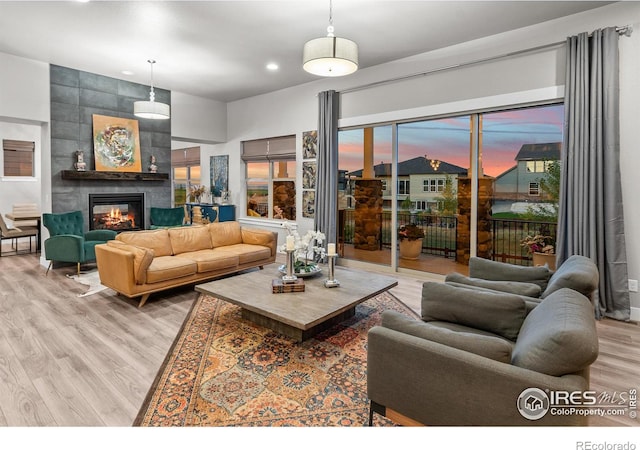 living room featuring a tile fireplace and light hardwood / wood-style floors