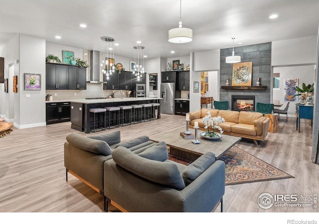 living room with a tiled fireplace and light hardwood / wood-style flooring