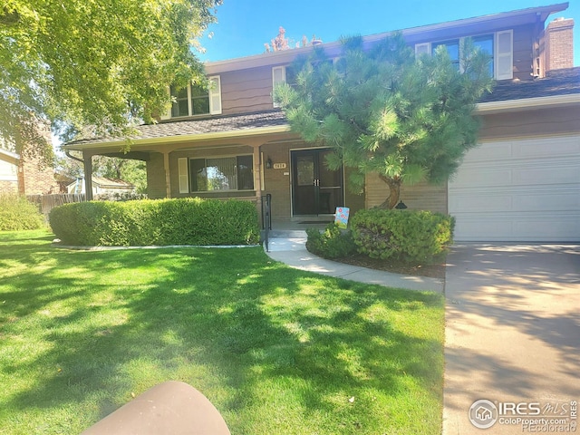 view of front of home with covered porch, a front yard, and a garage