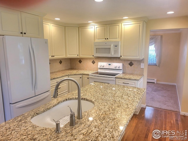 kitchen featuring baseboard heating, dark wood-type flooring, light stone counters, and white appliances