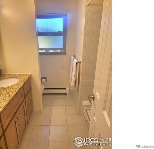 bathroom with vanity, toilet, a baseboard heating unit, and tile patterned flooring