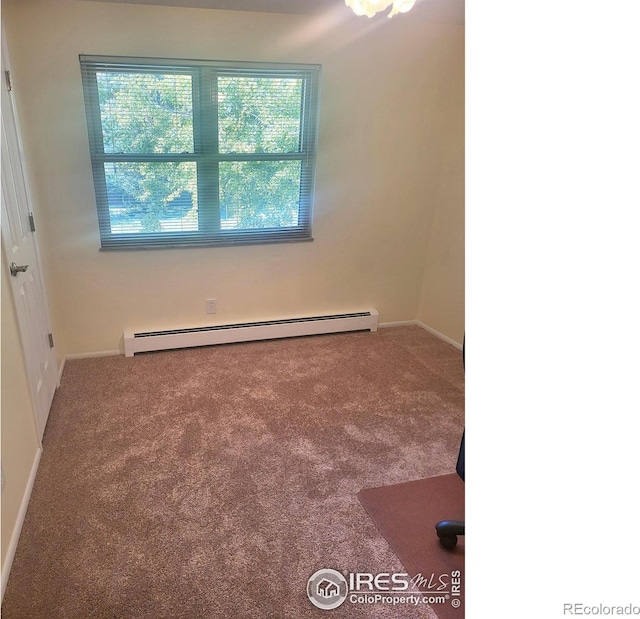 carpeted spare room featuring a baseboard radiator