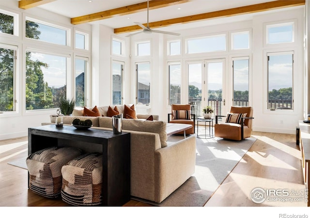 living room featuring ceiling fan, beam ceiling, and a healthy amount of sunlight