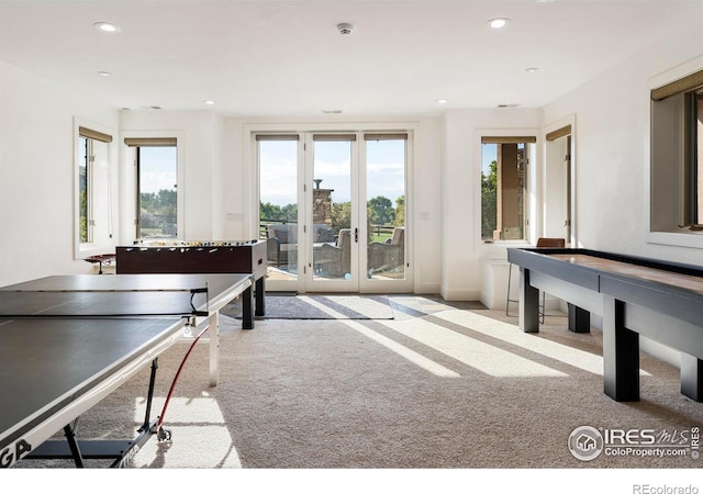 recreation room featuring french doors, light colored carpet, and plenty of natural light