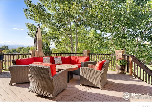 wooden terrace with an outdoor living space with a fire pit