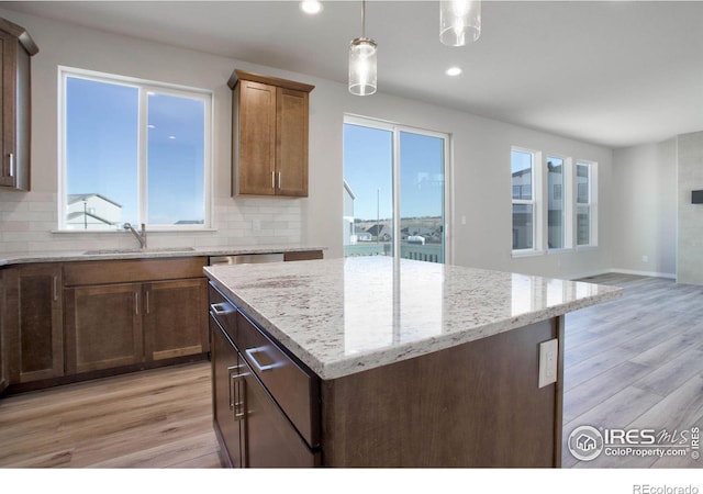 kitchen featuring light wood-type flooring, sink, and a wealth of natural light