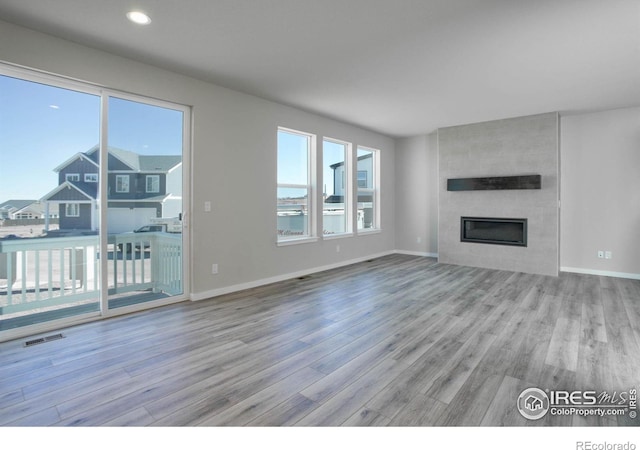 unfurnished living room with a fireplace and light hardwood / wood-style flooring