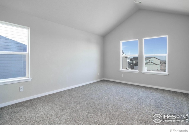 carpeted spare room with lofted ceiling